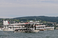 Sikorsky S-38 preparing for departure towards the wind. Tom Schrade, the pilot is standing on the bow of this masterpiece of aircraft. The MS Limmat in the background.